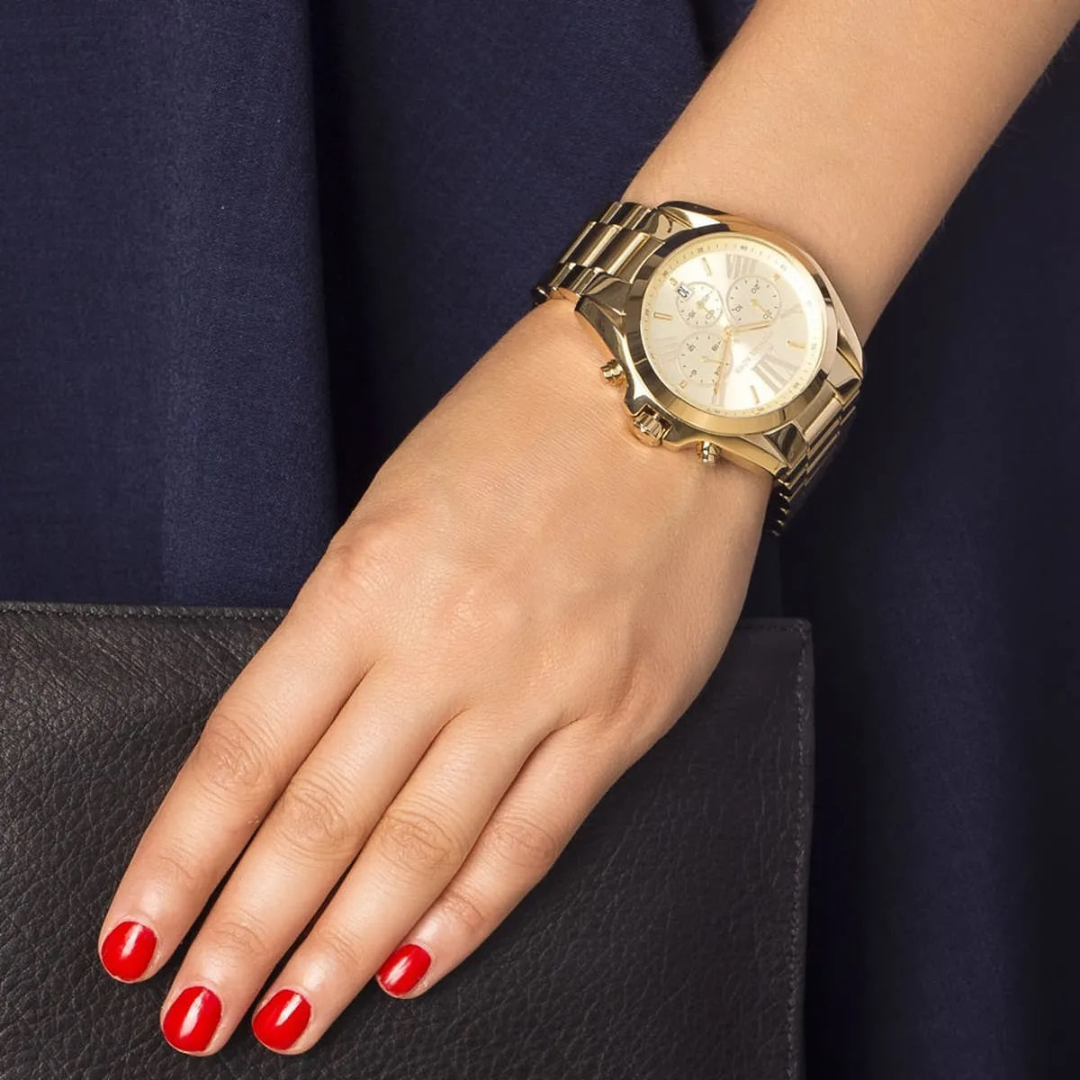 Wider view of Michael Kors MK5605 worn on wrist, displaying bold all-gold design
