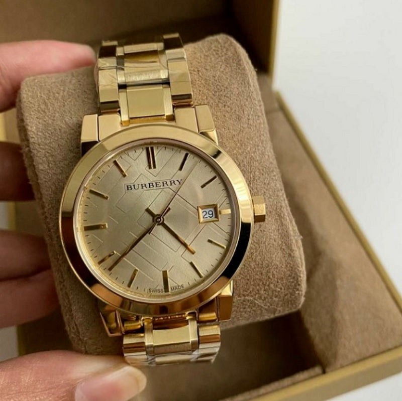 Burberry BU9134 The City gold watch displayed on branded pillow