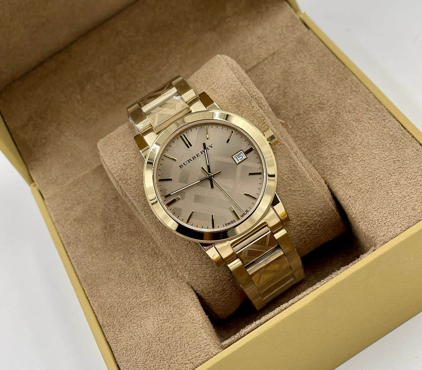 Burberry BU9038 unisex gold watch elegantly displayed in its branded packaging box with luxurious cushion