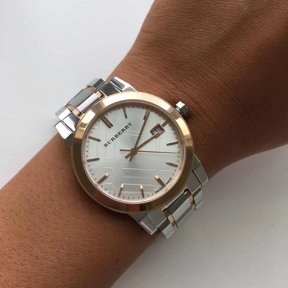 The Burberry BU9105 watch on a woman's wrist, showing its silver strap and rose gold case.