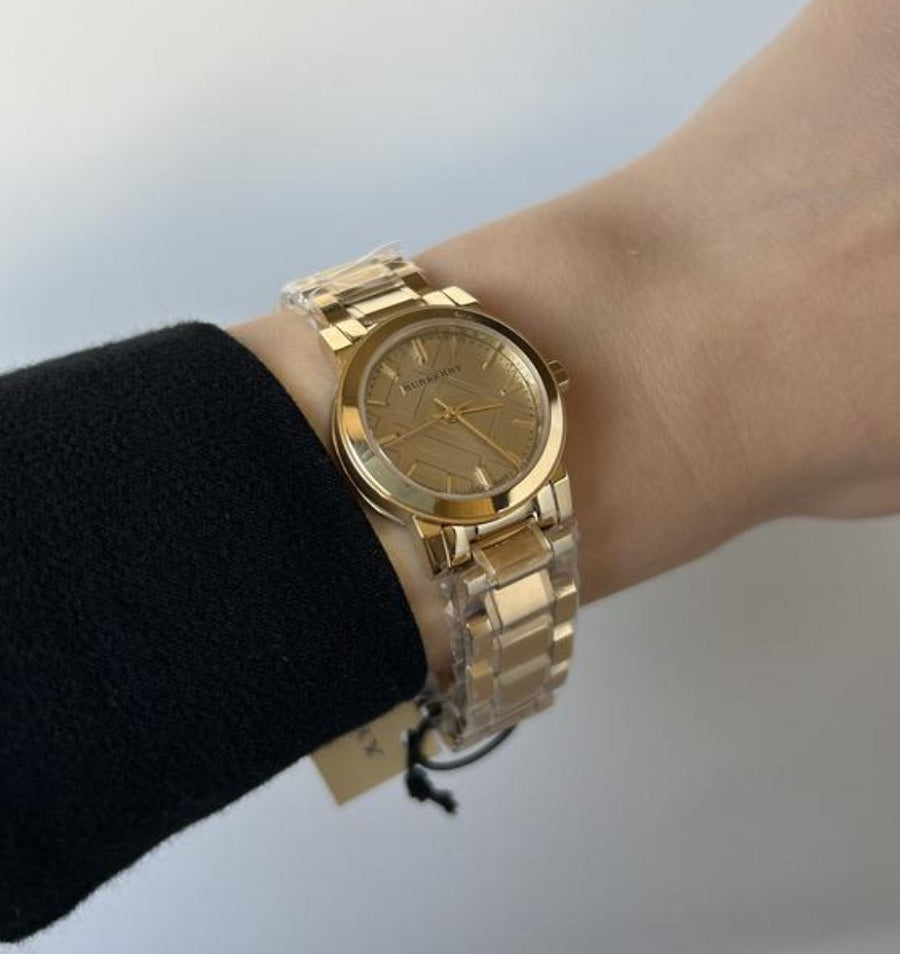 Burberry BU9227 The City women’s watch worn on wrist, featuring stainless steel gold strap and gold dial