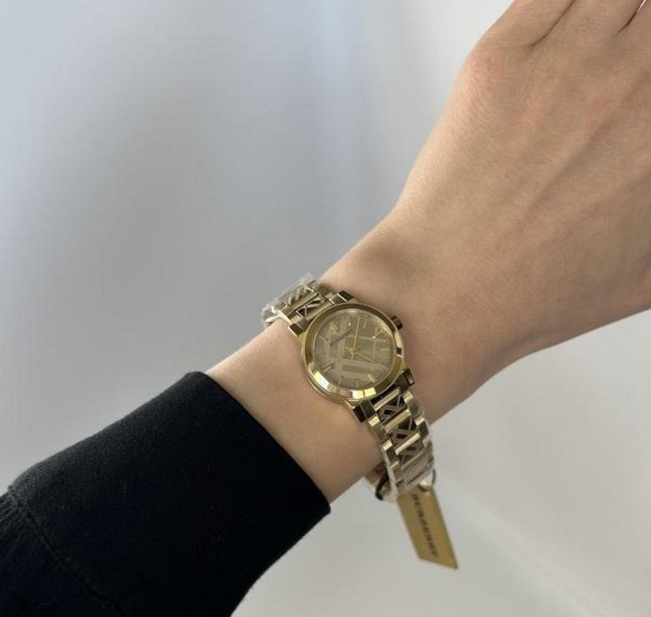 The Burberry BU9234 gold watch on a woman's wrist, showing size and fit.