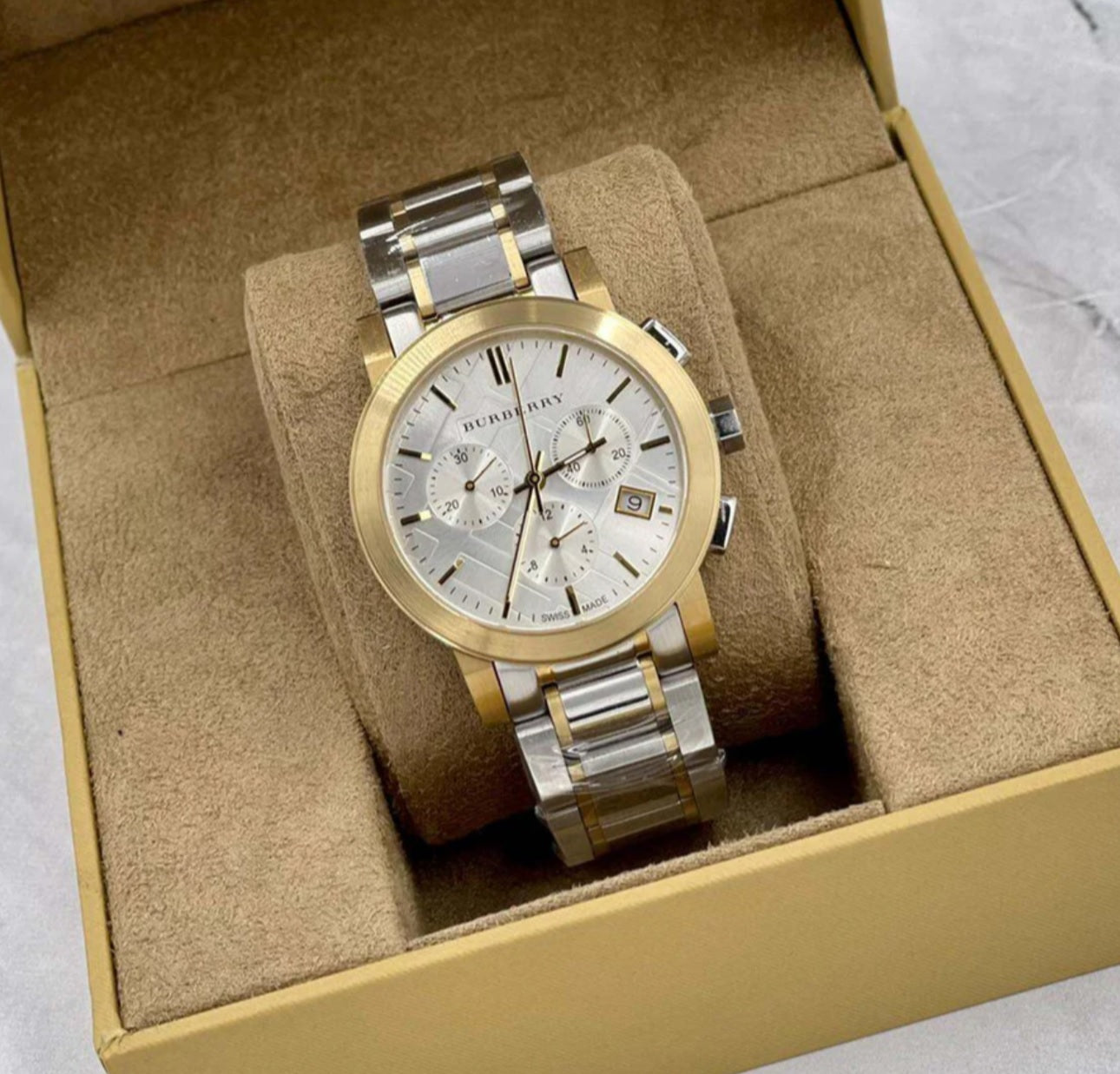 Burberry BU9751 silver and gold watch displayed on branded watch pillow