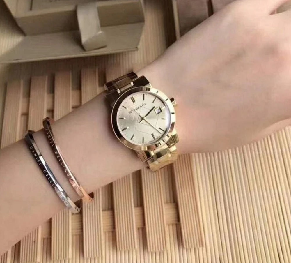 Burberry BU9134 gold women’s stainless steel watch shown on wrist in natural light