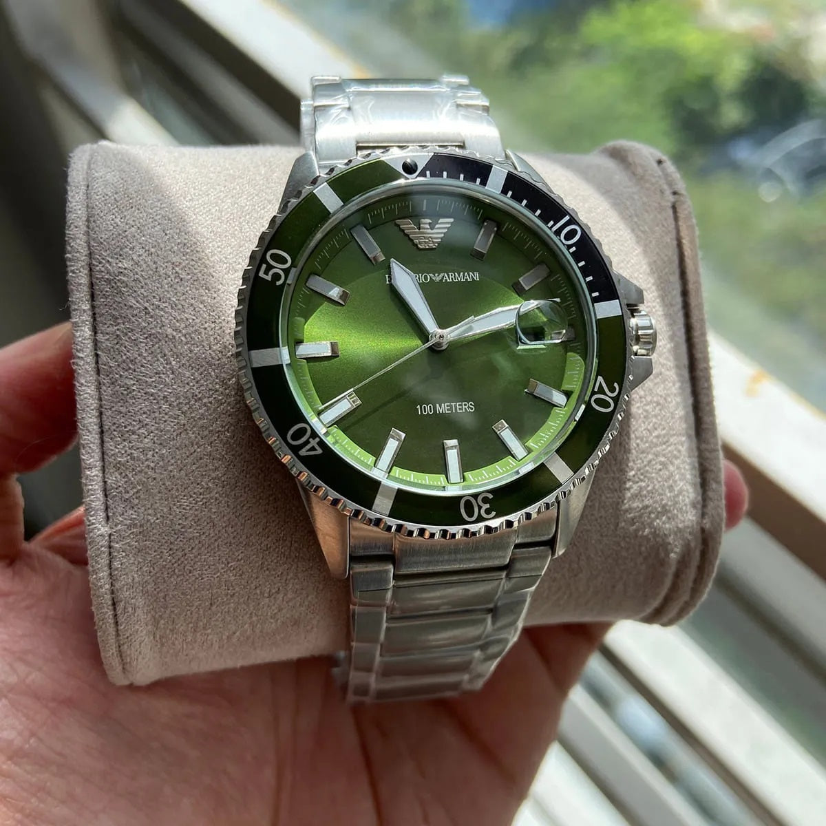 Emporio Armani AR11338 diver watch displayed around original branded pillow with silver strap and green dial