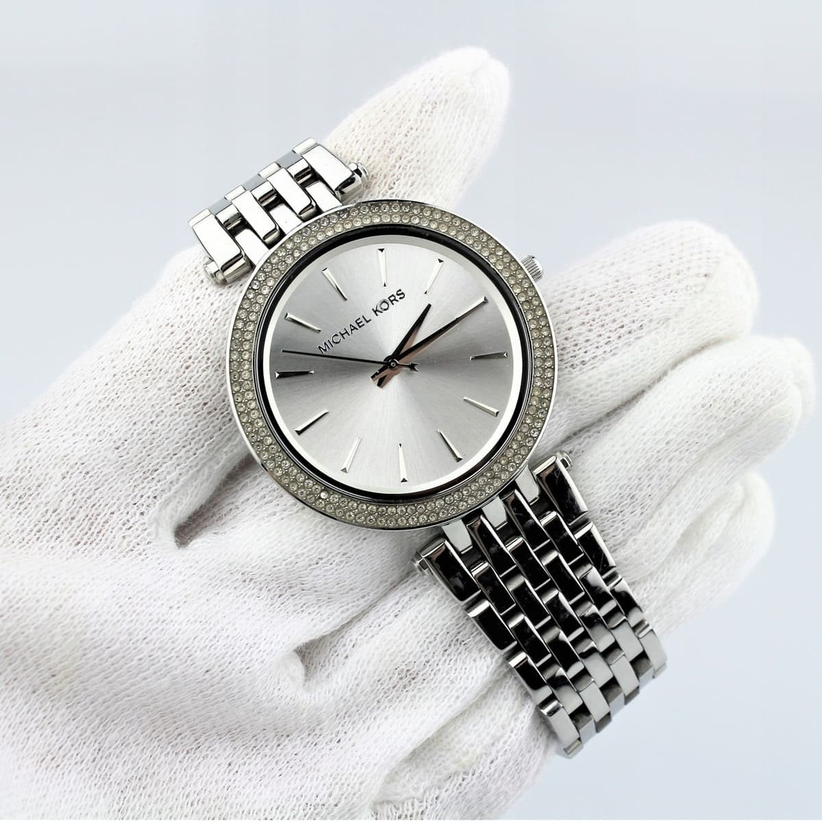 Michael Kors MK3190 women’s watch held in hands with white gloves, showcasing its elegant design