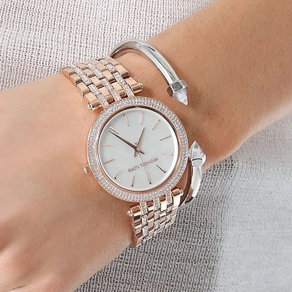 Michael Kors MK3220 women’s watch worn on wrist, highlighting its sophisticated design with rose gold strap and crystals