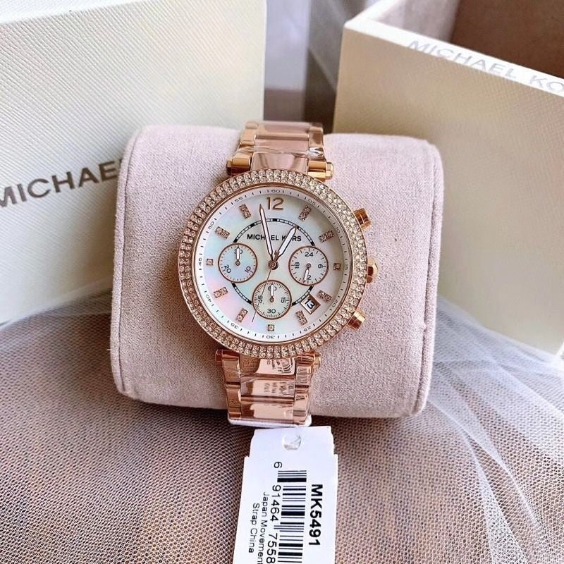 Michael Kors MK5491 women's rose gold watch displayed beside branded box and wrapped around cushion for presentation