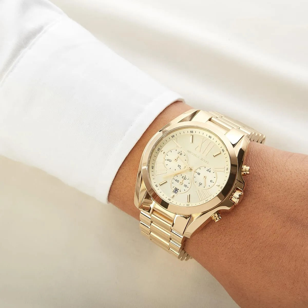 Close-up on wrist view of Michael Kors MK5605 highlighting gold dial and stra