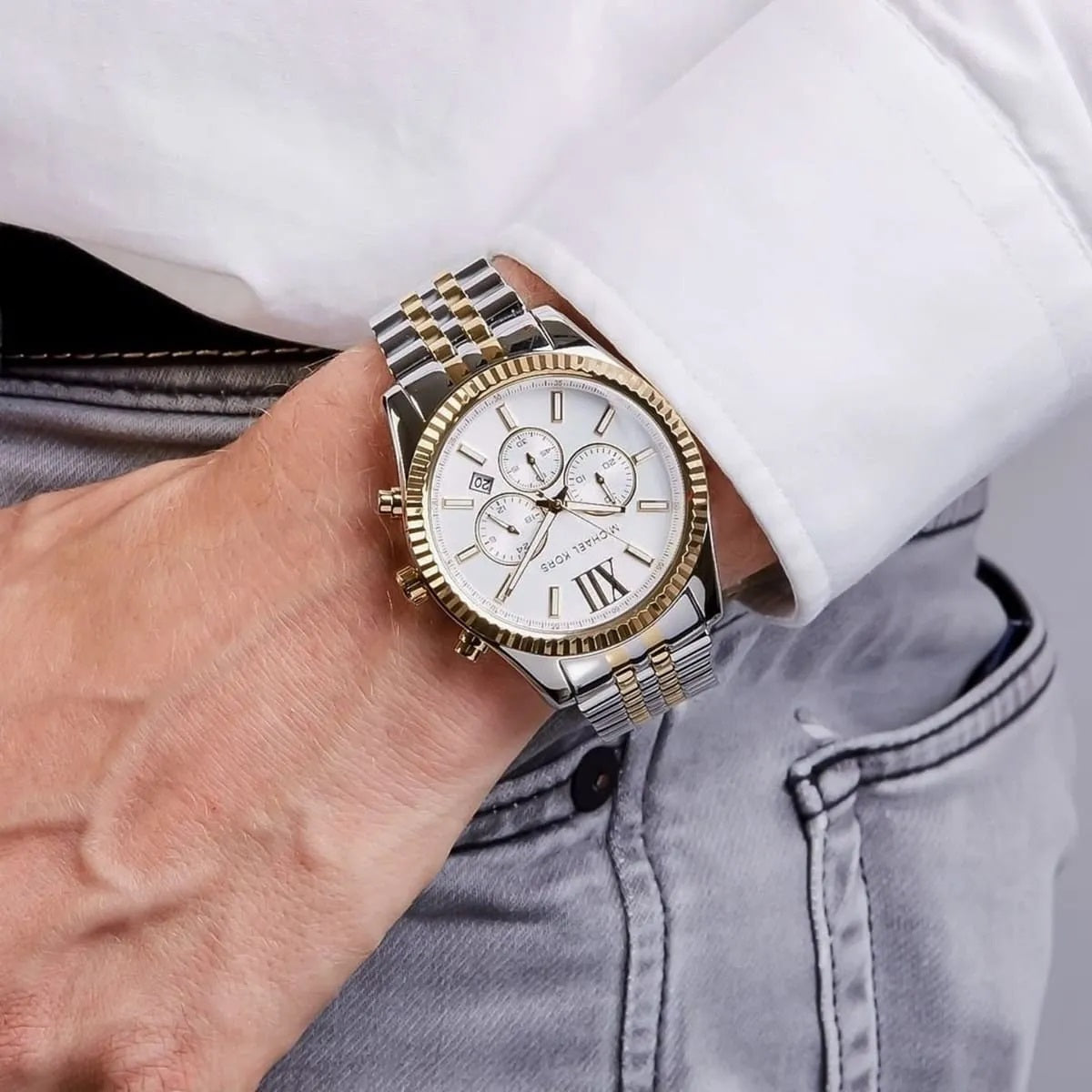 Close-up of dial hands and markers on Michael Kors MK8344 two-tone men's watch with silver dial