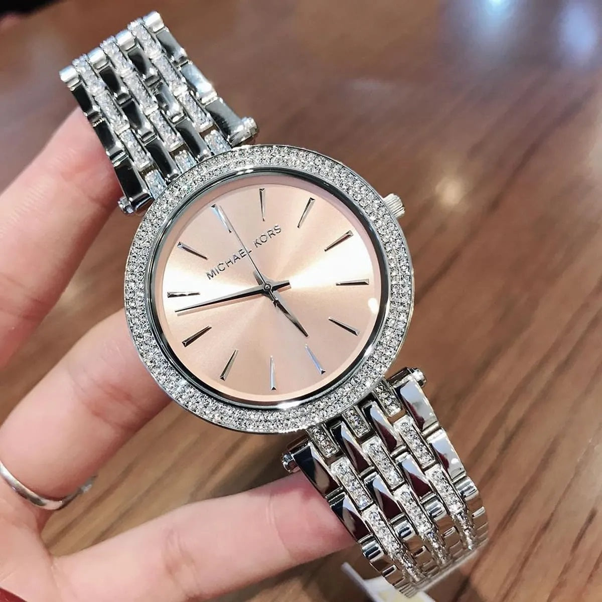 MK3218 silver watch held in hand close-up