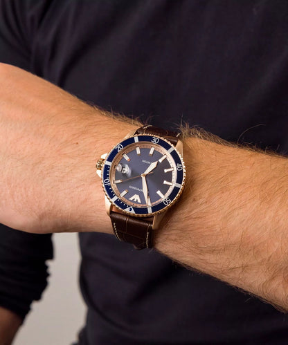 Emporio Armani AR11556 rose gold watch on men's wrist showing brown leather strap fit and blue dial contrast.