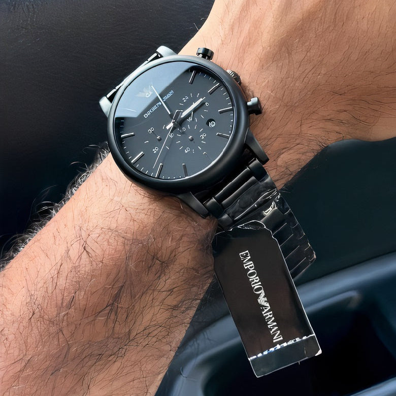Man wearing Emporio Armani AR1895 black chronograph watch on wrist, showing outdoor natural lighting and size reference.