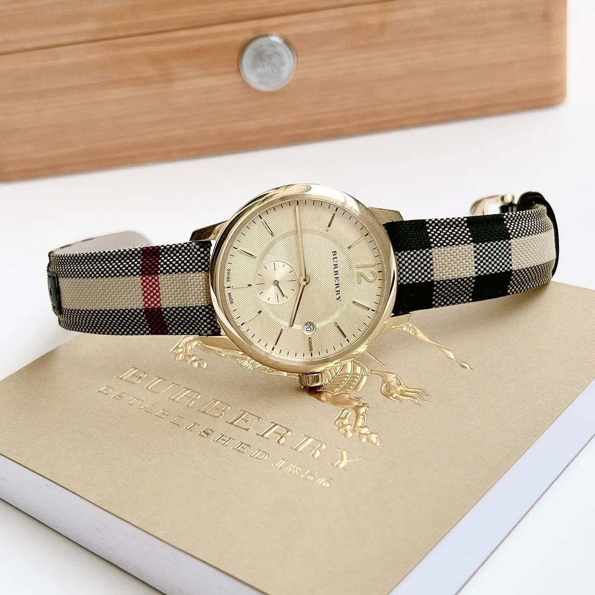 Close-up of gold dial and leather multicolour strap on Burberry BU10001 men's watch