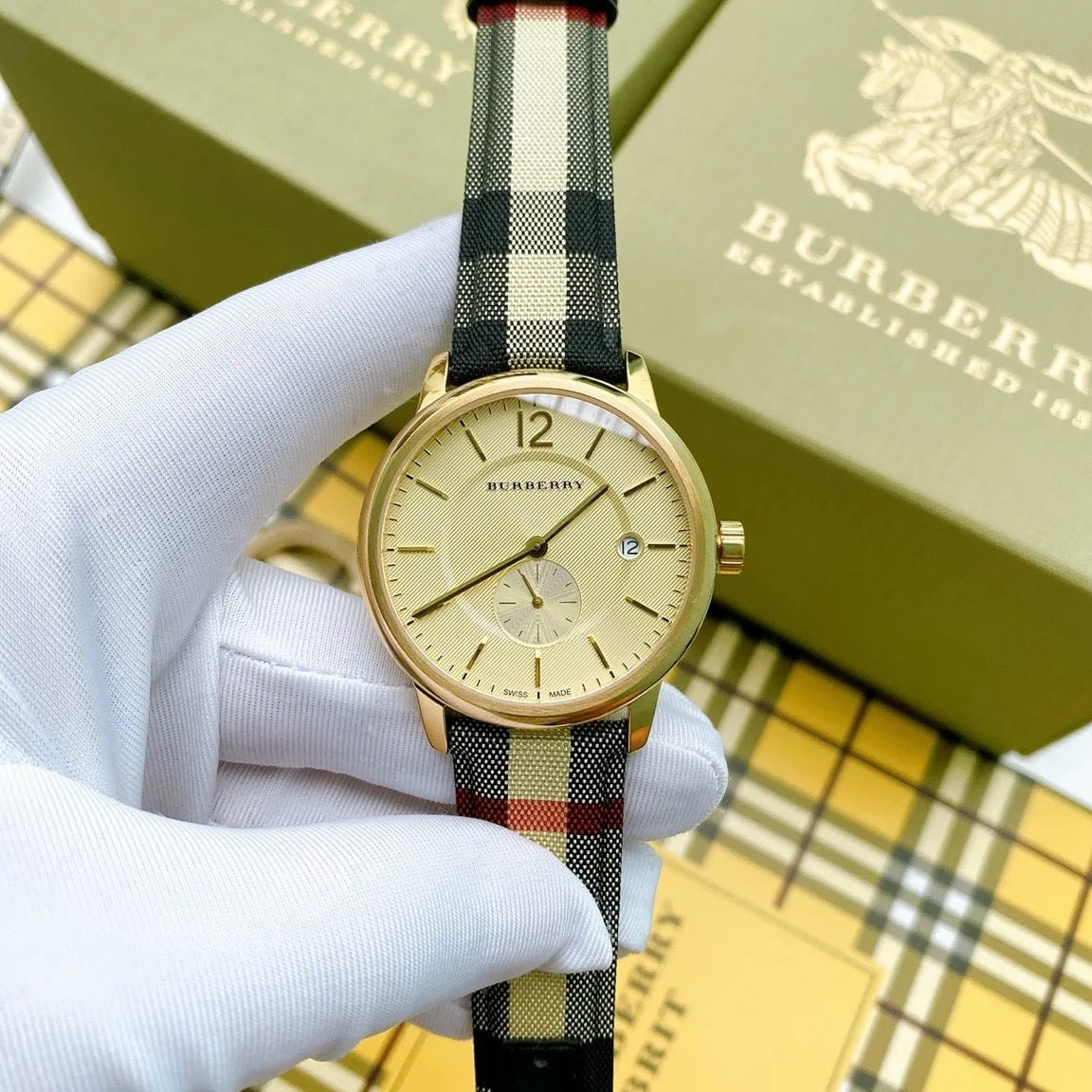 Close-up of gold dial and leather multicolour strap on Burberry BU10001 men's watch