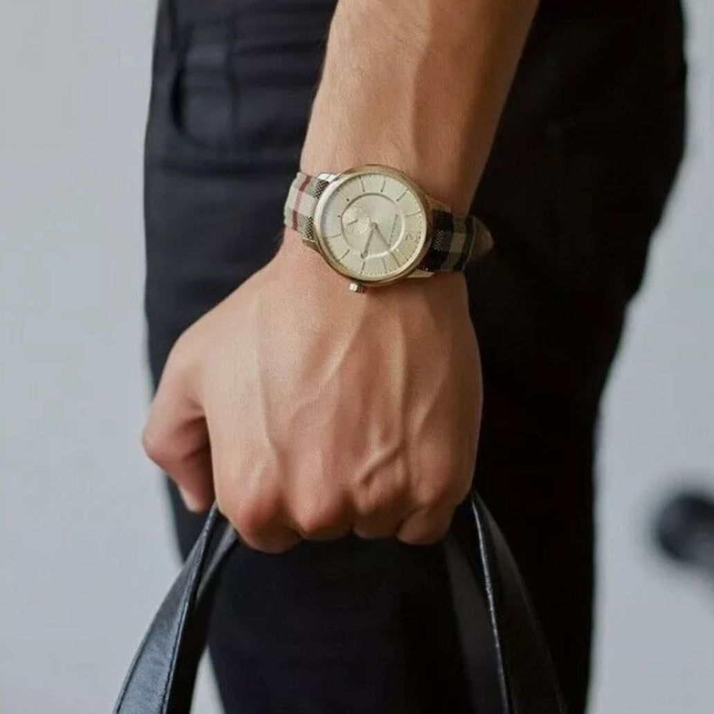 Burberry BU10001 men's watch worn on wrist with leather multicolour strap, gold dial, and gold case