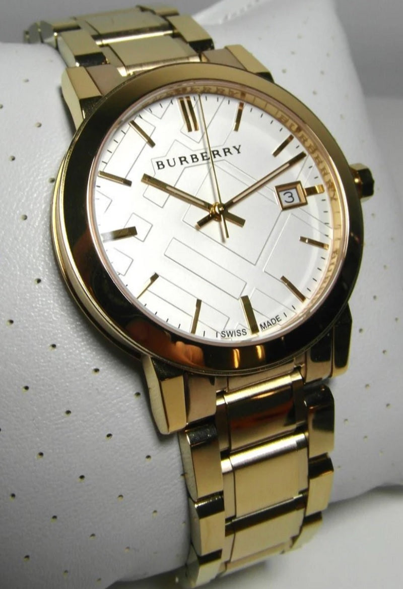 Burberry BU9003 unisex gold watch resting on a display cushion, showing its elegant presentation and reflective metallic finish.