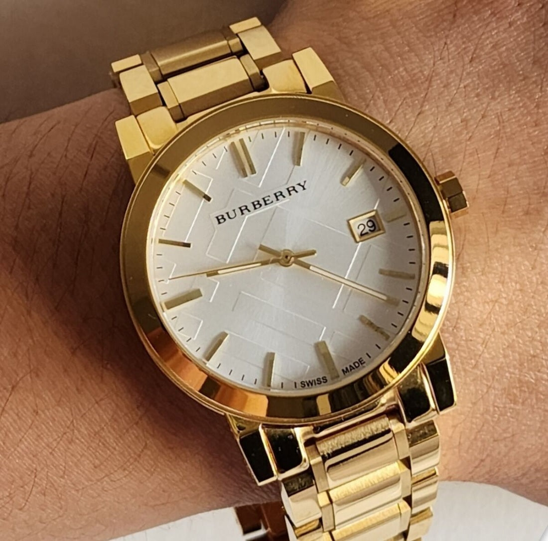Person wearing the Burberry BU9003 The City gold watch on their wrist to demonstrate size, fit, and everyday style.