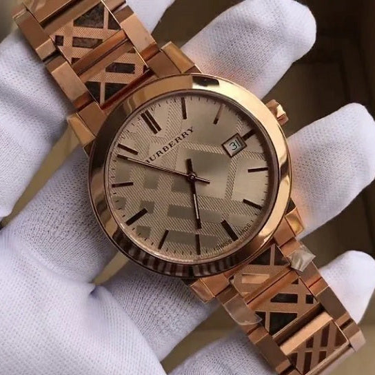 Gloved hand holding the Burberry BU9039 rose gold watch, highlighting its metallic finish and intricate check pattern details.