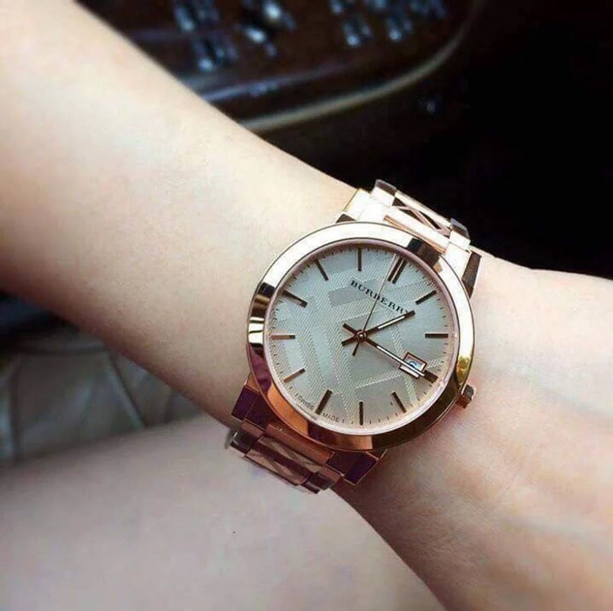 Person wearing the Burberry BU9039 The City rose gold watch on their wrist to demonstrate size, fit, and everyday style.