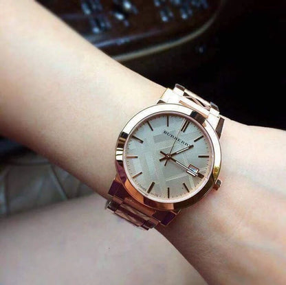 Person wearing the Burberry BU9039 The City rose gold watch on their wrist to demonstrate size, fit, and everyday style.