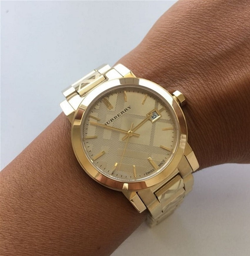 Woman wearing the Burberry BU9145 The City gold watch on her wrist, demonstrating the elegant fit and signature check details.