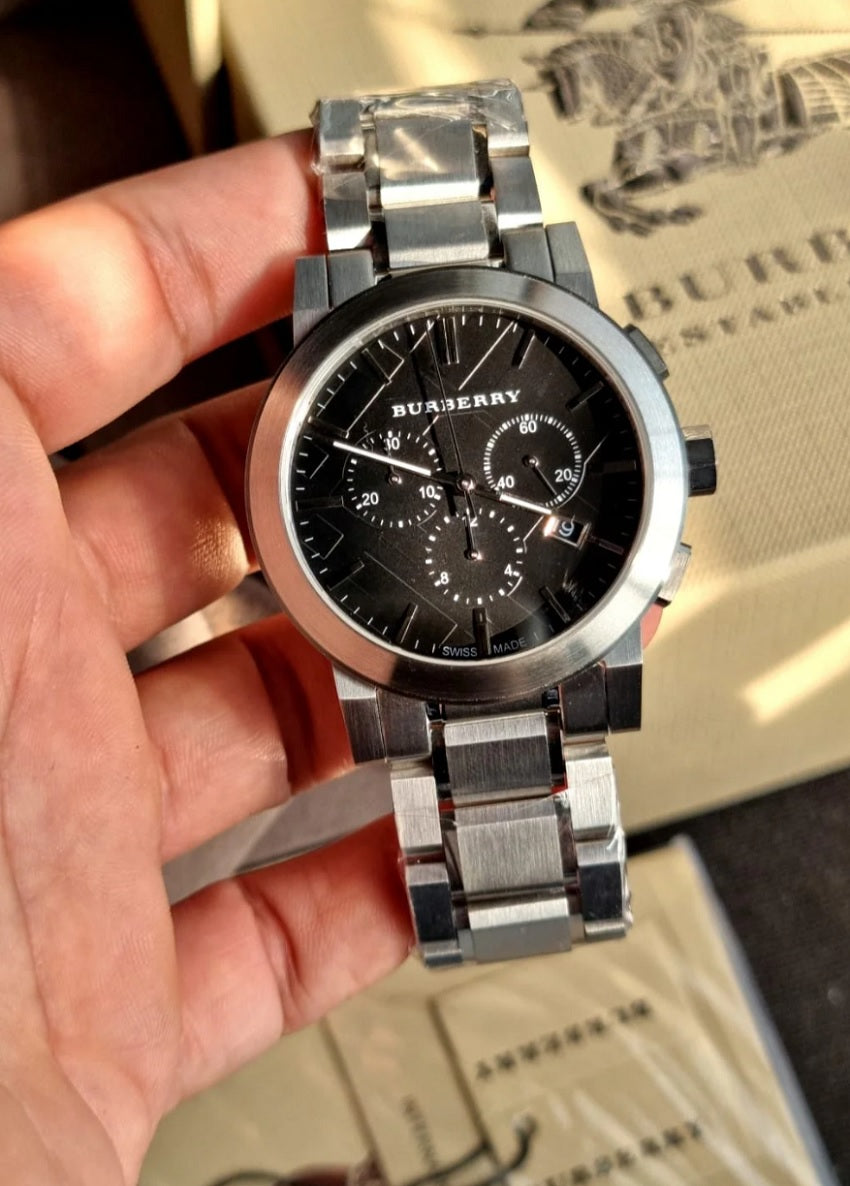 Close-up of Burberry BU9351 The City men’s watch in hands, highlighting the silver bracelet and black dial