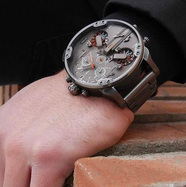 Close-up wrist shot of the massive Diesel DZ7315 watch resting on a brick surface, demonstrating its bold 57mm case fit and rugged styling.