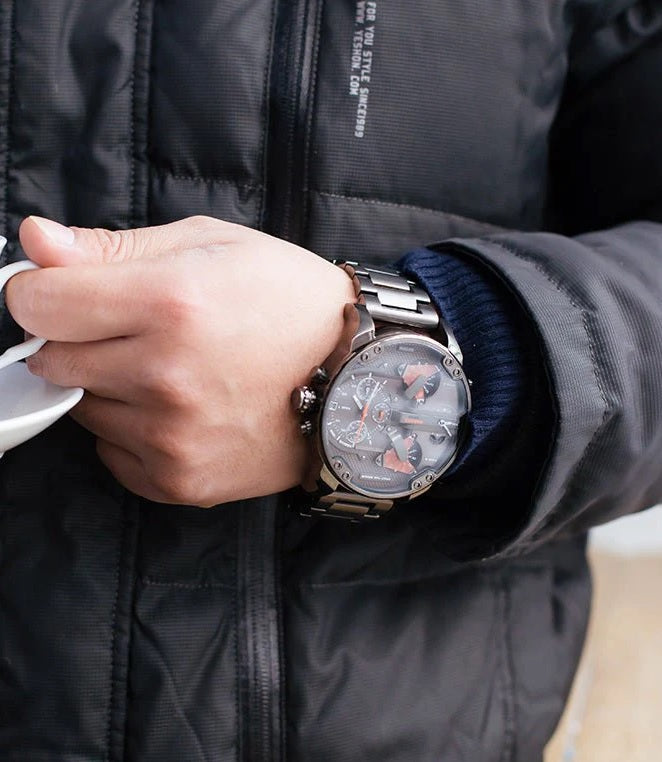 Man wearing the oversized Diesel DZ7315 gunmetal watch, styled with a casual black winter jacket to demonstrate everyday streetwear fashion.
