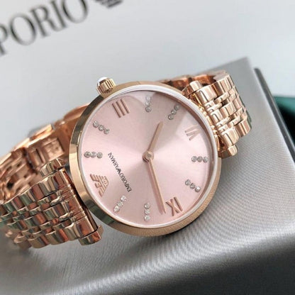 Close-up of the gold dial on Emporio Armani AR11059 Gianni T-Bar women’s watch with rose gold blush strap