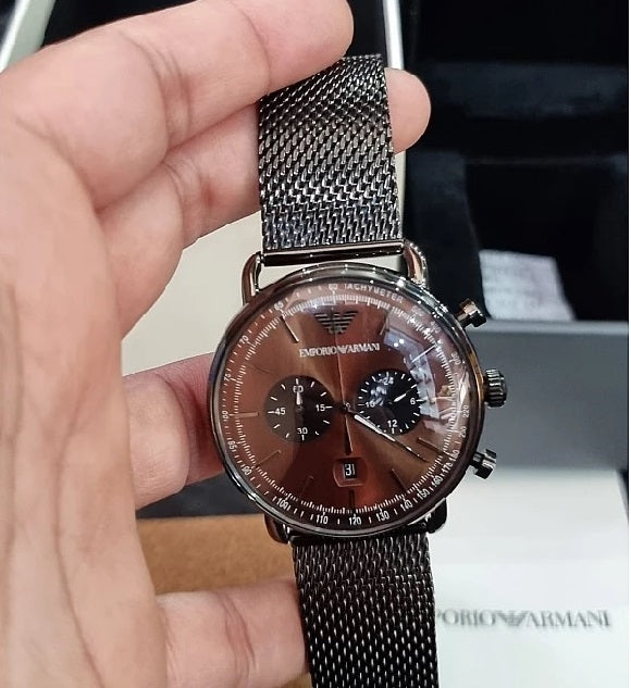 Lifestyle photo of the Emporio Armani AR11141 watch held in hand to show its 43mm size and how the brown dial looks in natural light