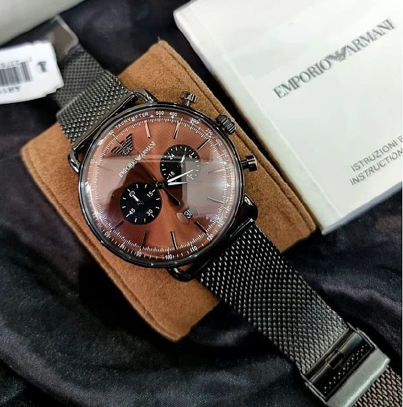 Front view of the Emporio Armani AR11141 Aviator watch with its grey mesh strap, displayed on the official branded pillow