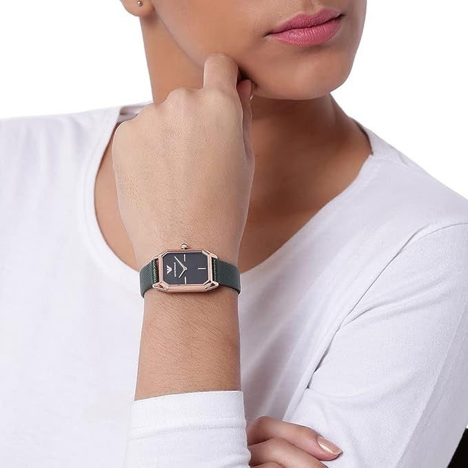 Lifestyle image of a woman wearing the Emporio Armani AR11149 Gioia watch, paired with a white top to highlight the elegant green and rose gold design.