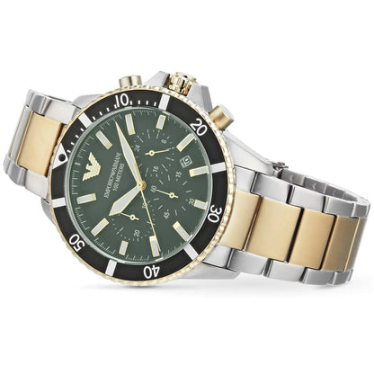 Angled view of the Emporio Armani AR11361 two-tone watch resting flat, showcasing the green diver bezel and stainless steel link bracelet.