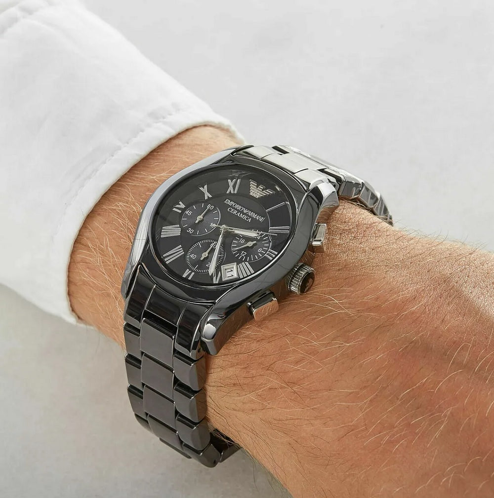 Man wearing the Emporio Armani AR1400 black ceramic watch on his wrist, styled with a white shirt to demonstrate its luxury aesthetic and fit.