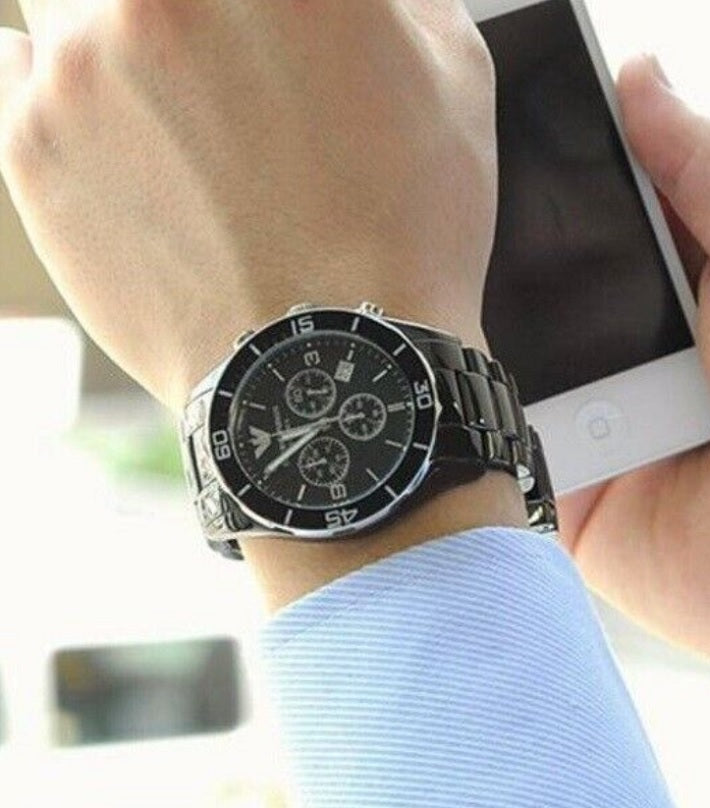 Emporio Armani AR1421 worn on wrist, showcasing the black ceramic strap and black chronograph dial
