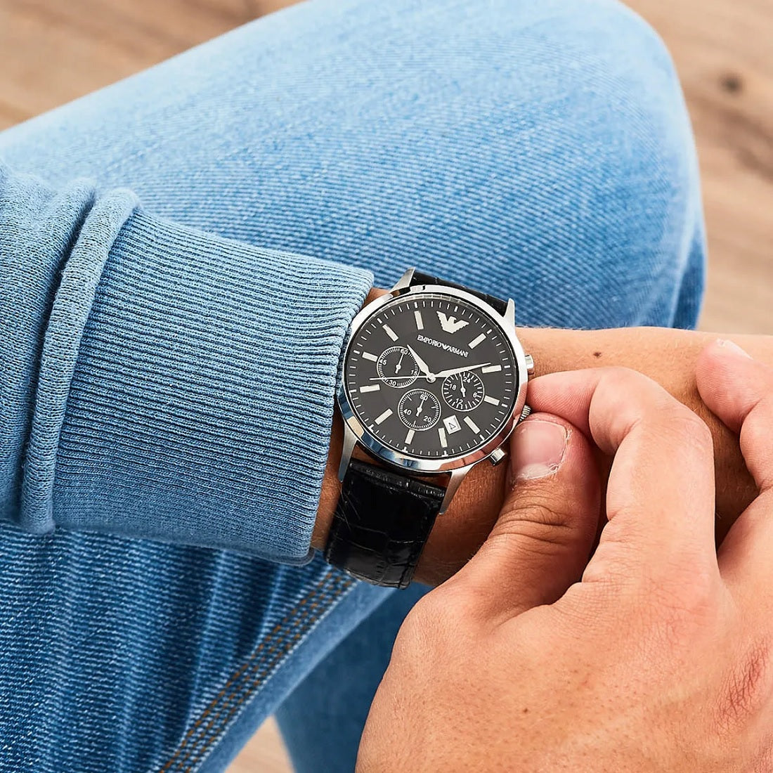Emporio Armani AR2447 worn on wrist with black leather strap and minimalist black dial