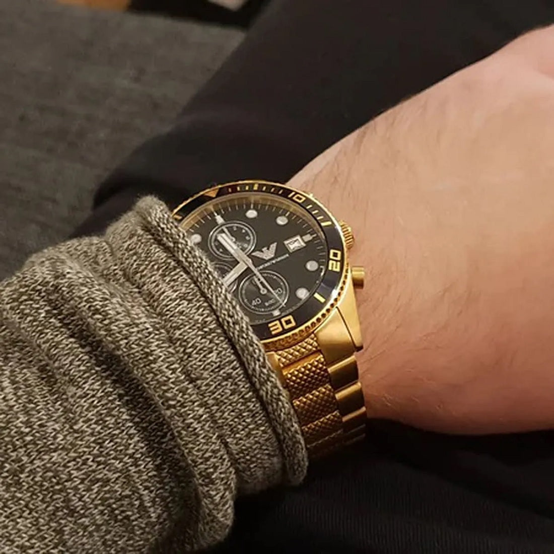 Close-up wrist shot of Emporio Armani AR5857 with black dial and yellow gold strap