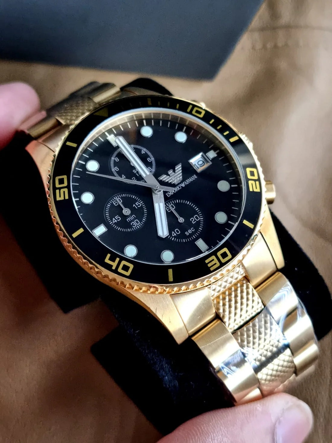 Emporio Armani AR5857 men’s watch displayed on branded watch display cushion with yellow gold strap and black dial