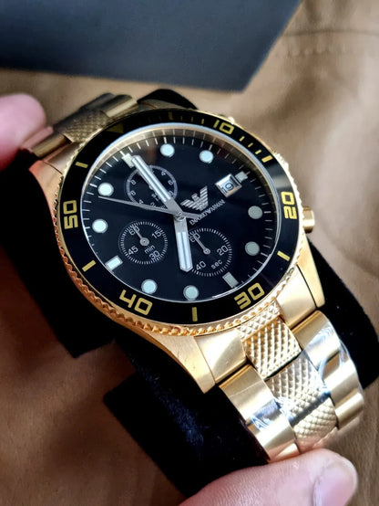 Emporio Armani AR5857 men’s watch displayed on branded watch display cushion with yellow gold strap and black dial