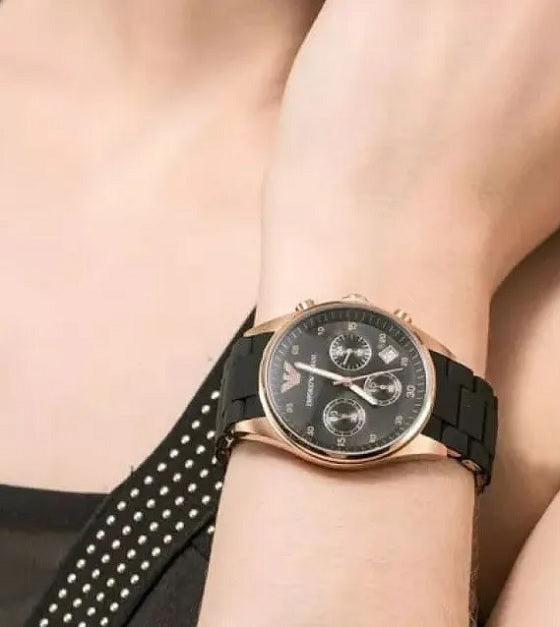 Close-up wrist shot of Emporio Armani AR5906 with black dial, rose gold case, and black silicone strap