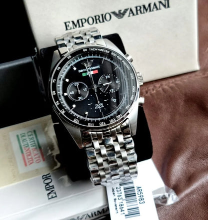 Emporio Armani AR5983 Tazio men’s watch displayed on branded pillow with stainless steel silver strap and black dial