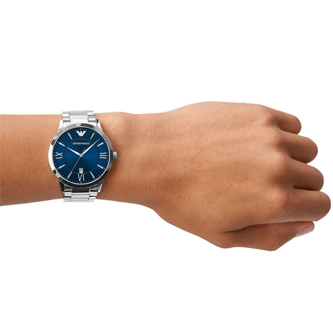 Studio model wrist shot showing the fit and sizing of the Emporio Armani blue dial watch on a male wrist against a white background.