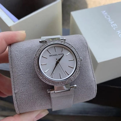 Michael Kors MK3367 displayed in box and resting on pillow, showcasing its silver dial and mesh strap