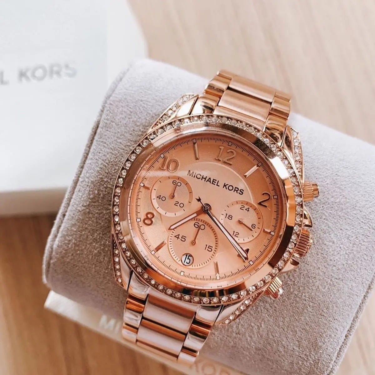 Michael Kors MK5263 rose gold watch displayed next to branded box and resting on presentation pillow