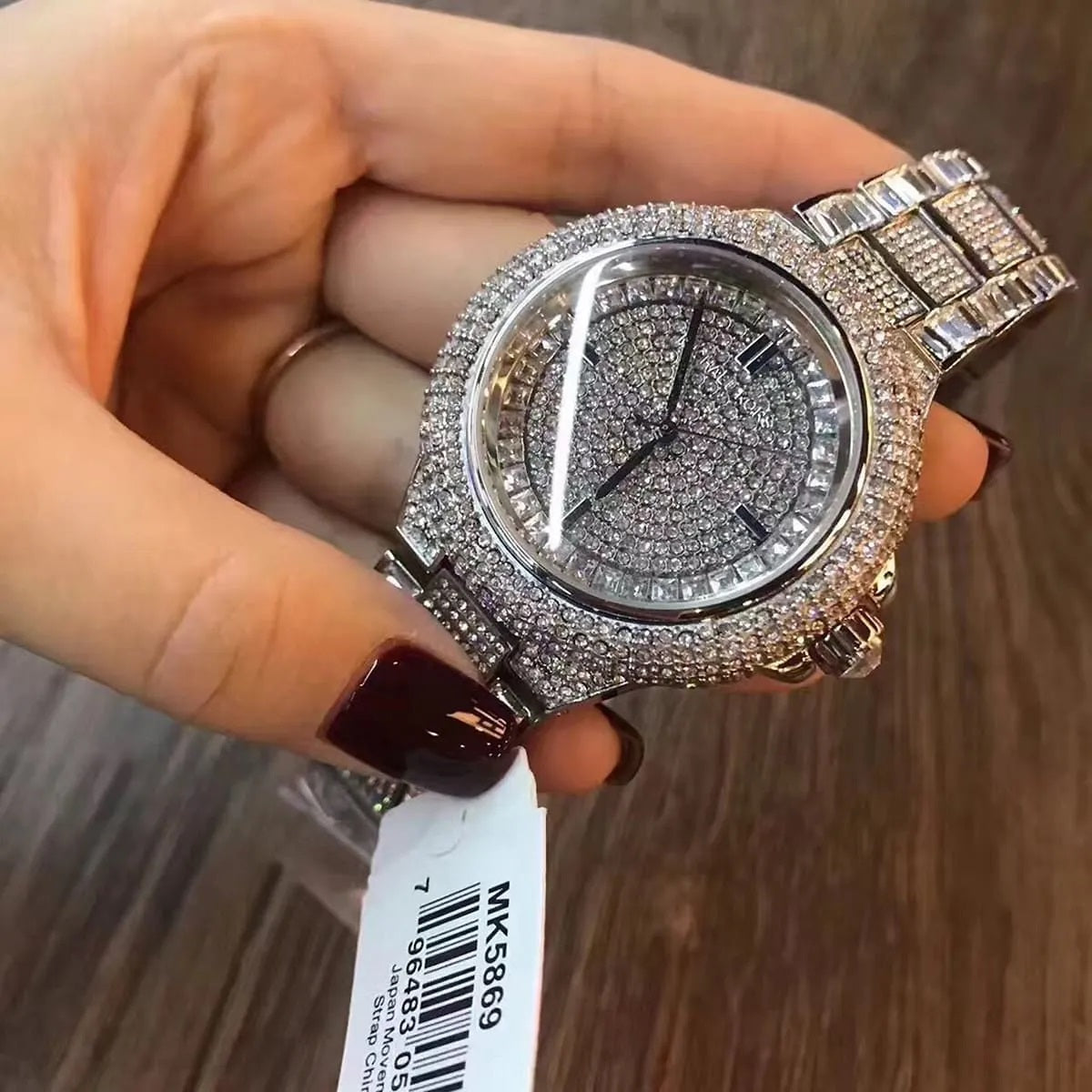 Handheld shot of the Michael Kors MK5869 Camille watch capturing the shimmer of the pavé crystals and reflective metallic finish.