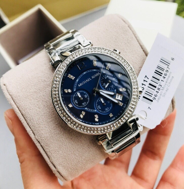 Handheld view of the Michael Kors MK6117 Parker watch showing the retail price tag and the shimmer of the crystal-set bezel.