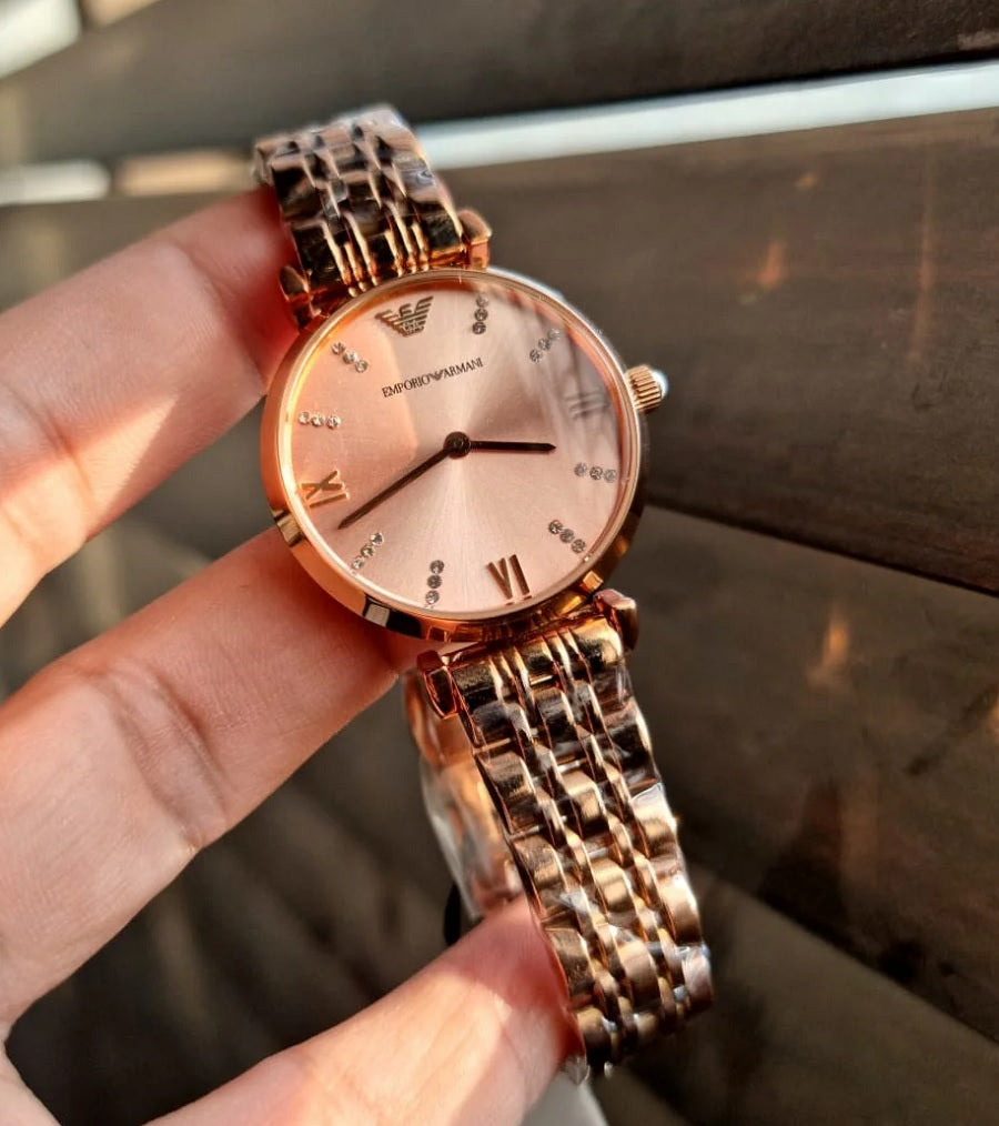 Emporio Armani AR11059 Gianni T-Bar women’s watch with stainless steel rose gold blush strap and gold dial in hands