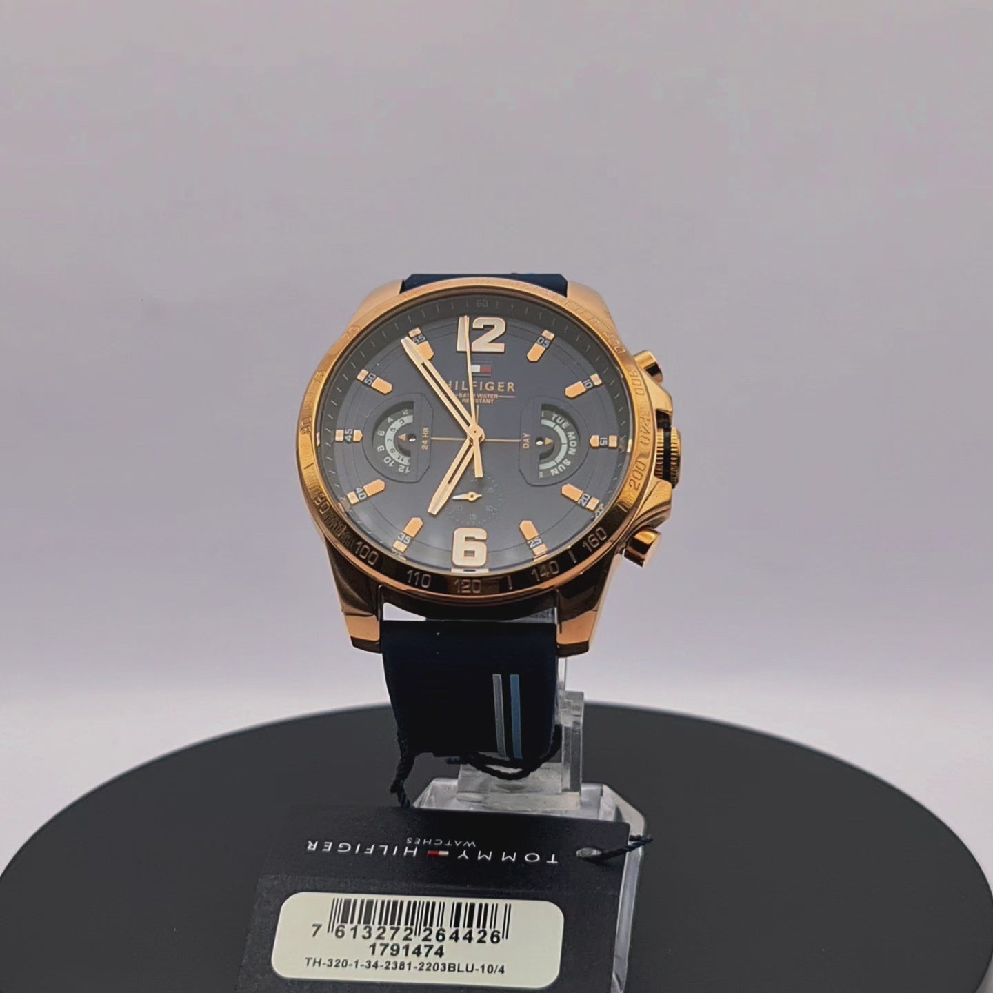 360-degree rotating view of Tommy Hilfiger 1791474 Decker men's silver watch with white dial and navy blue silicone strap.