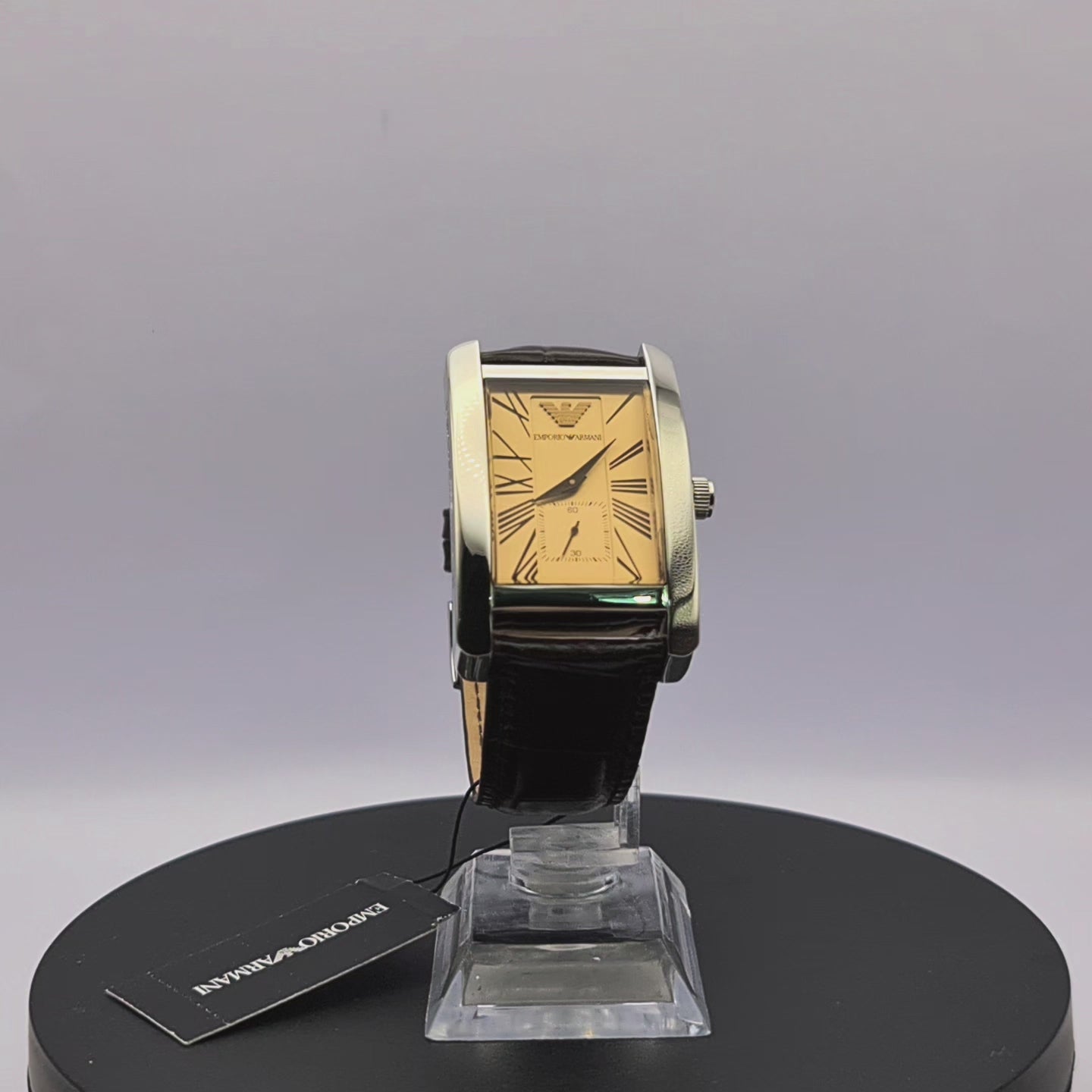 "360-degree rotating view of Emporio Armani AR0154 men's silver stainless steel watch with beige dial, brown leather strap, and rectangular case.